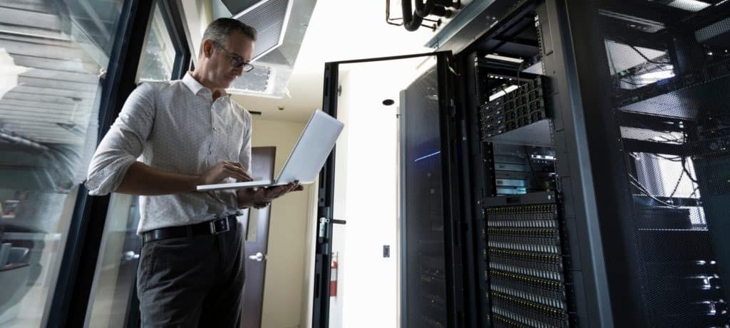 Man using laptop in server room