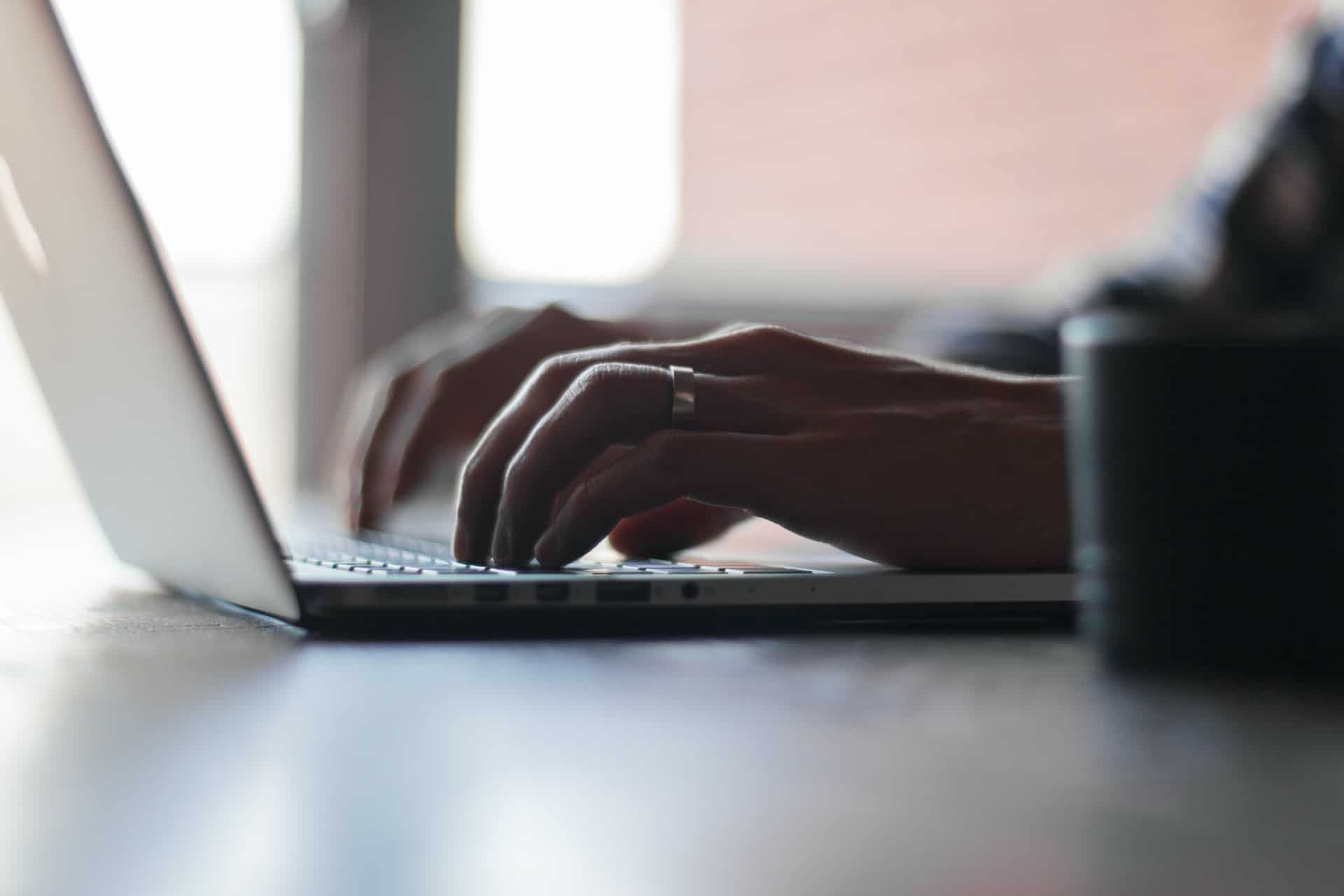 Hands writing on laptop