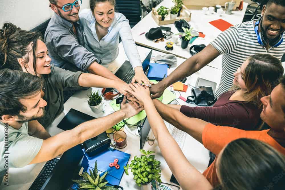 Young employee startup workers group stacking hands at urban studio during entrepreneurship brainstorming project - Business concept of human resources on working time - Start up internship at office